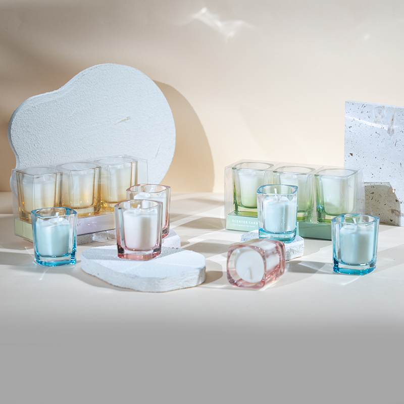 그라데이션 색상으로 설정된 정사각형 양초 3개